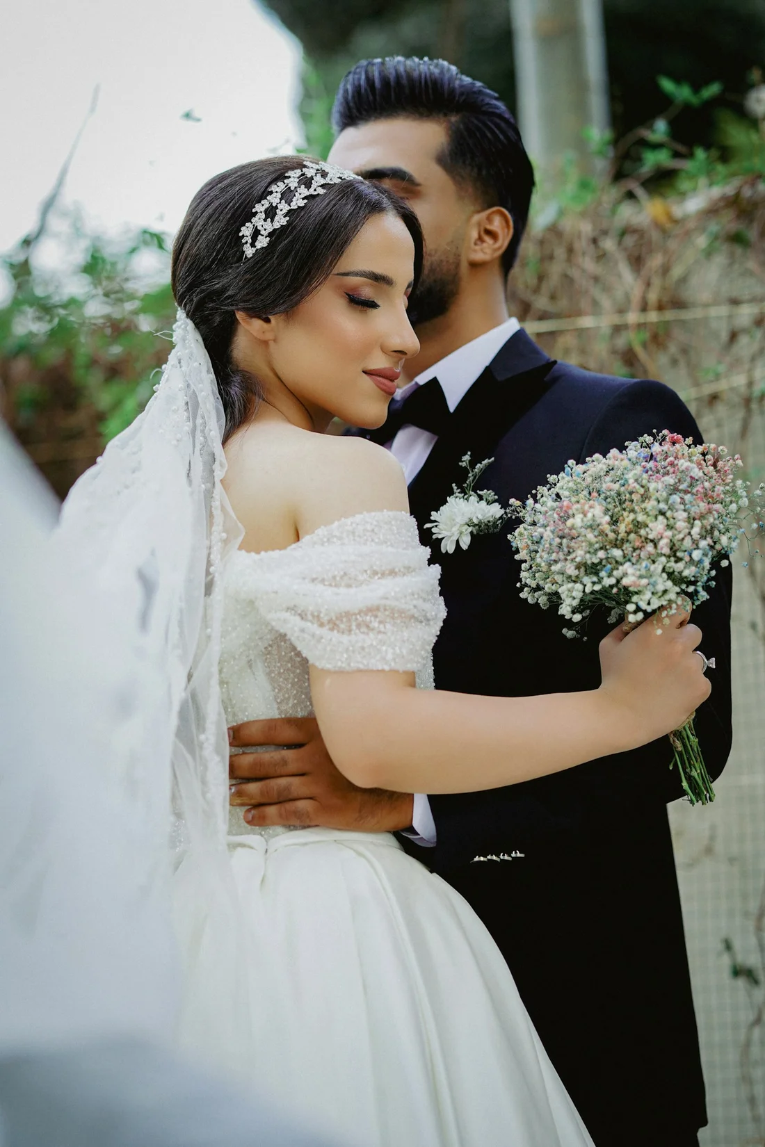 Newlyweds embracing with a bouquet